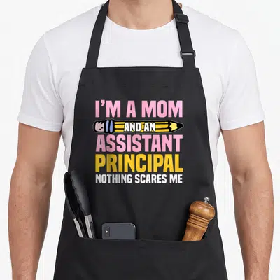 Deputy mother's day aprons - I'M A MOM AND AN ASSISTANT PRINCIPAL text with pencil graphic in pink yellow white black — shown on a black cotton canvas apron against a white background