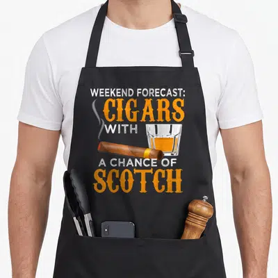 Forecast weekend mode apron - Realistic brown cigar and scotch glass over stacked orange and white text — shown on a black cotton canvas apron against a white background