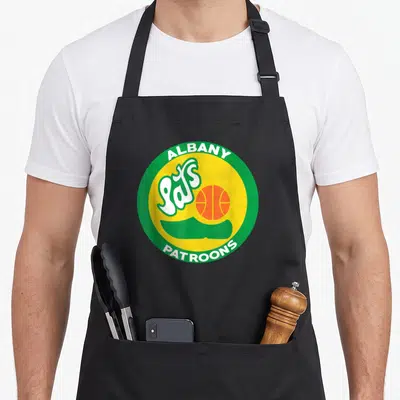 Albany albanian apron - Circular Albany Pats Patroons basketball logo with green border yellow center and script — shown on a black cotton canvas apron against a white background