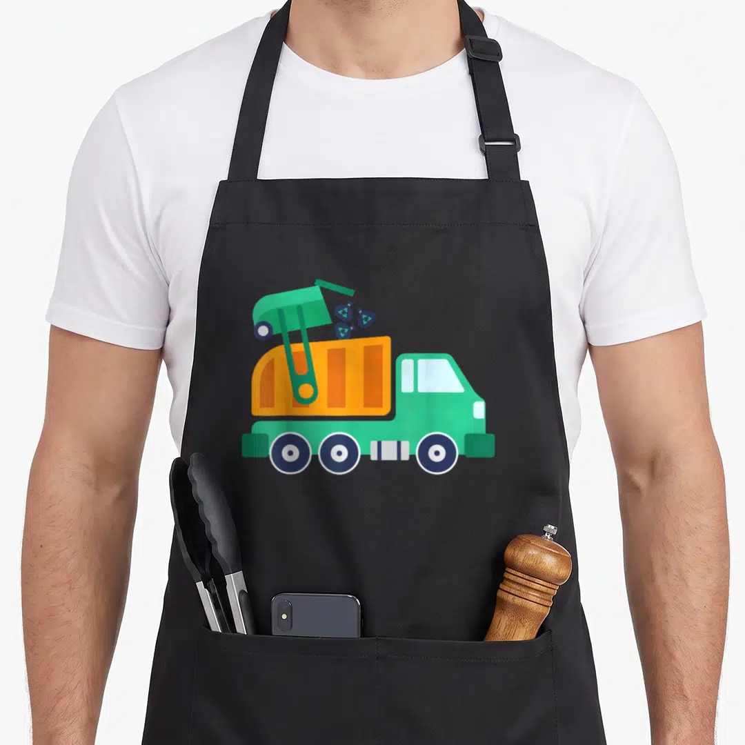 Earth truck apron - Cartoon green and orange garbage truck tipping dark blue recycling symbols into hopper — shown on a black cotton canvas apron against a white background