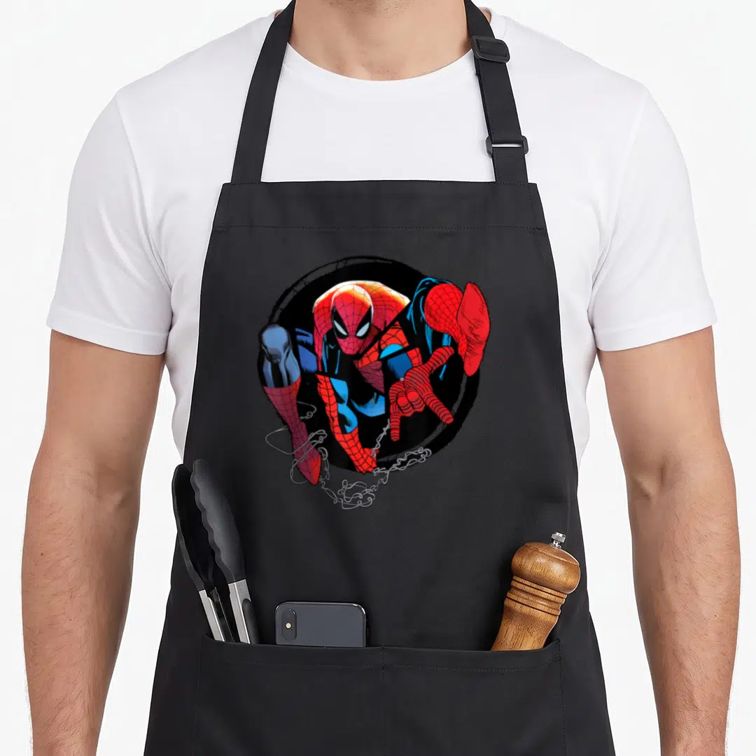 Web amazing aprons - Spider-Man in red blue and black circle with white webbing extending from bottom left — shown on a black cotton canvas apron against a white background