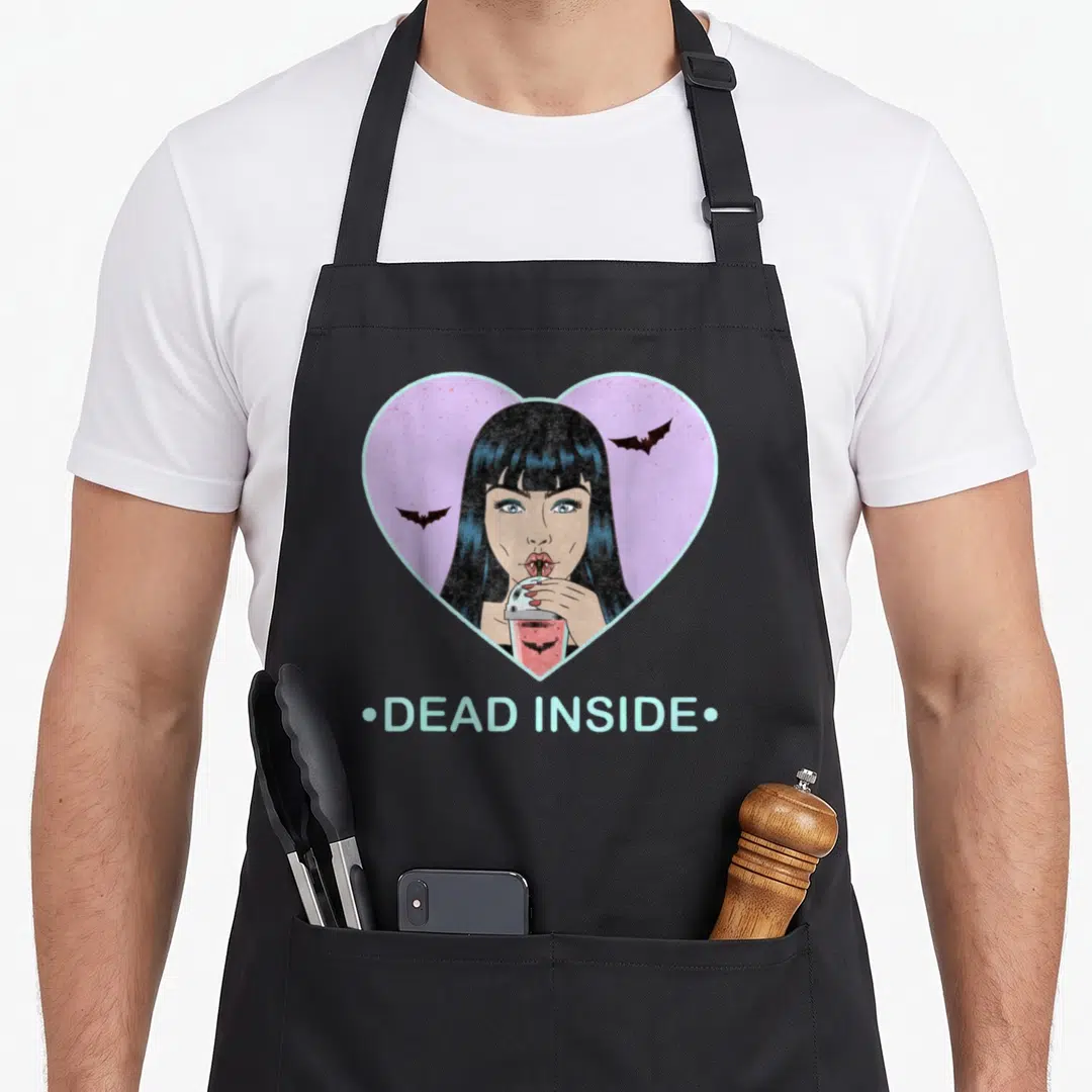 Dead goth apron - Cartoon vampire woman in pink heart with two bats and DEAD INSIDE text — shown on a black cotton canvas apron against a white background