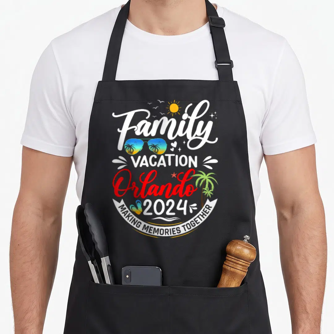 Vacation orlando family aprons - Stacked text reading Family Vacation Orlando 2024 with sunglasses and palm tree — shown on a black cotton canvas apron against a white background
