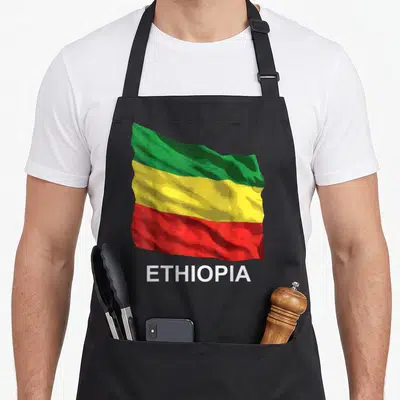 Flag ethiopian apron - Waving green yellow red flag with white ETHIOPIA text below — shown on a black cotton canvas apron against a white background
