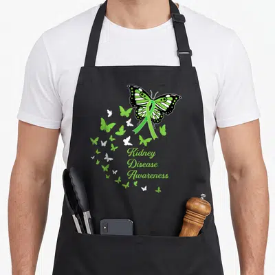 Ckd butterfly apron - Green ribbon butterfly with Kidney Disease Awareness text and smaller swirling butterflies — shown on a black cotton canvas apron against a white background