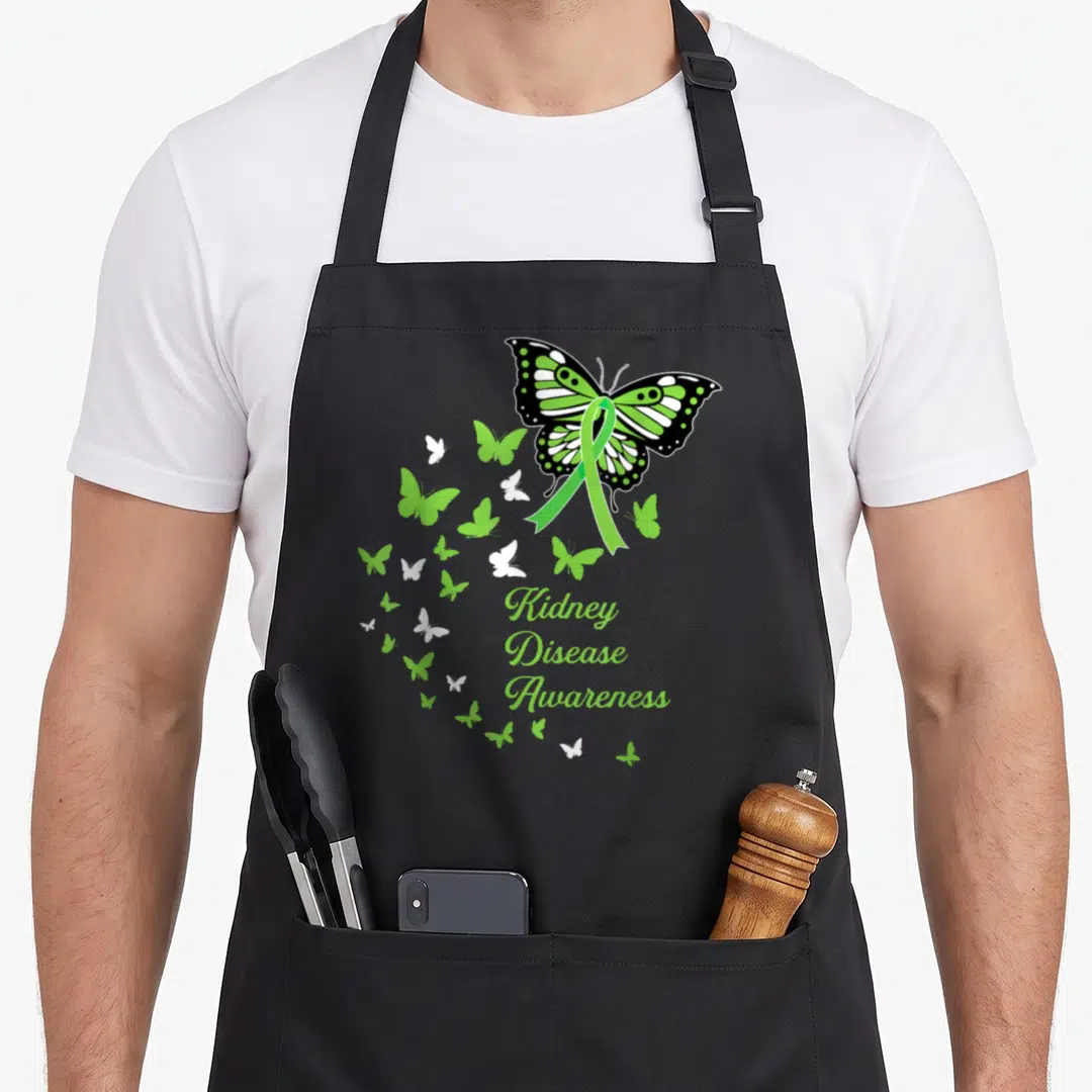 Ckd butterfly apron - Green ribbon butterfly with Kidney Disease Awareness text and smaller swirling butterflies — shown on a black cotton canvas apron against a white background