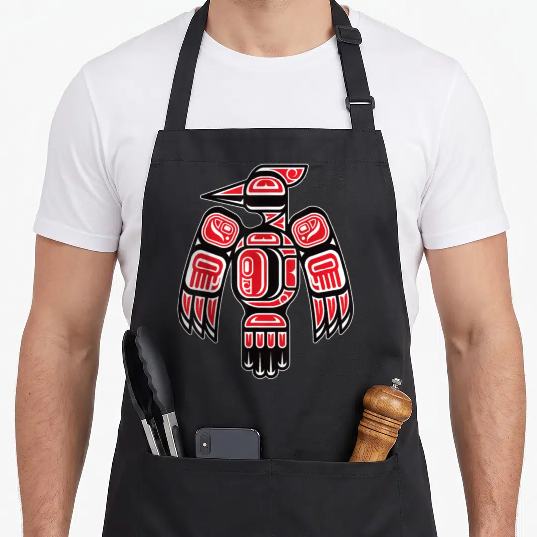 Haida native american apron - Stylized red black and white woodpecker in Haida line art style centered on fabric — shown on a black cotton canvas apron against a white background