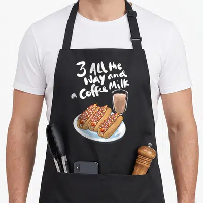 Hot weiner apron - Three chili dogs and coffee milk glass with stacked white text — shown on a black cotton canvas apron against a white background