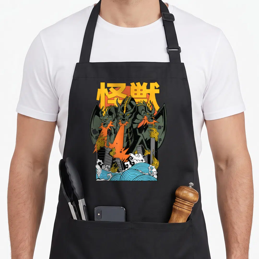 Japanese king apron - Three-headed dragon breathing fire with orange kanji and blue waves — shown on a black cotton canvas apron against a white background