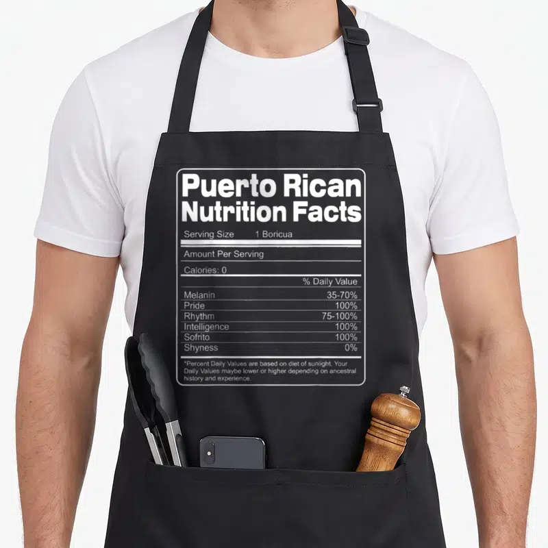 Nutrition rican apron - White nutrition facts label listing 1 Boricua serving size, 100% Pride, Rhythm, and Sofrito — shown on a black cotton canvas apron against a white background