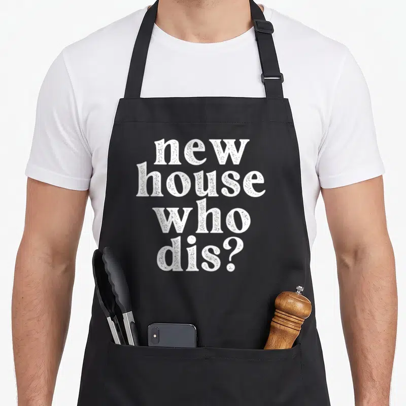 Dis housewarming apron - white stacked text reading new house who dis — shown on a black cotton canvas apron against a white background