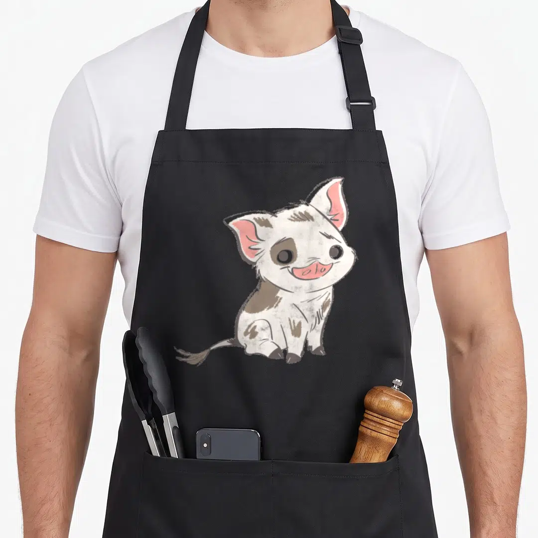 Drawn novelty apron - Cartoon pig sitting with white fur, brown patches, and pink ears — shown on a black cotton canvas apron against a white background