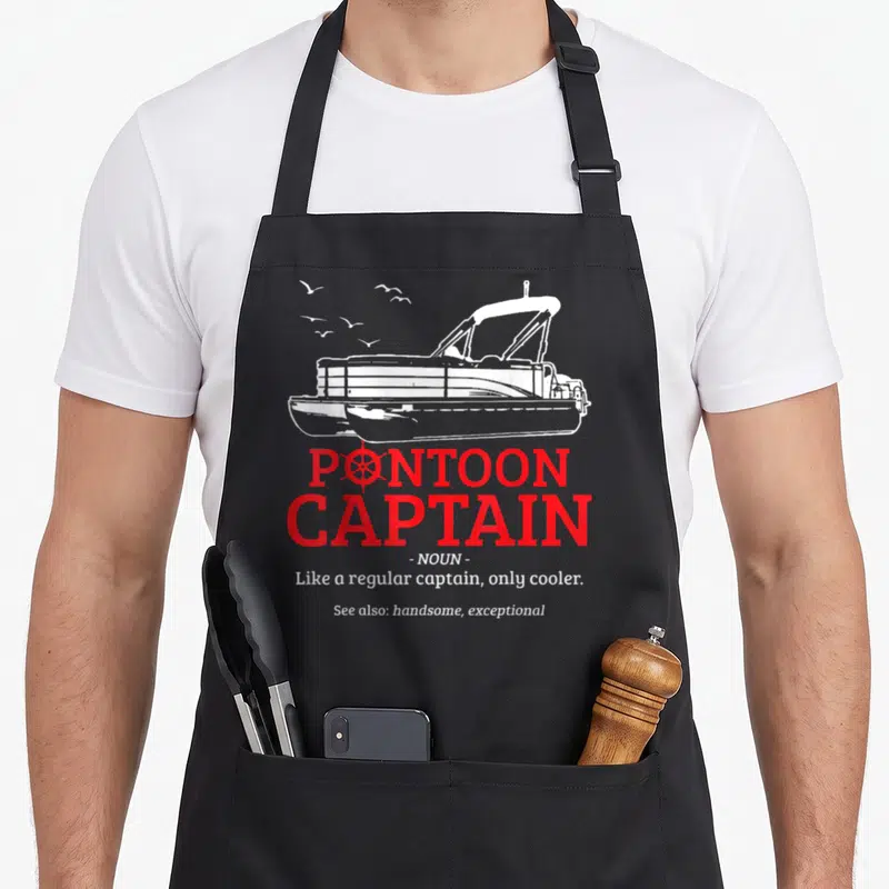 Pontoon boating quotes apron - White cartoon pontoon boat and birds above red and white dictionary definition text — shown on a black cotton canvas apron against a white background