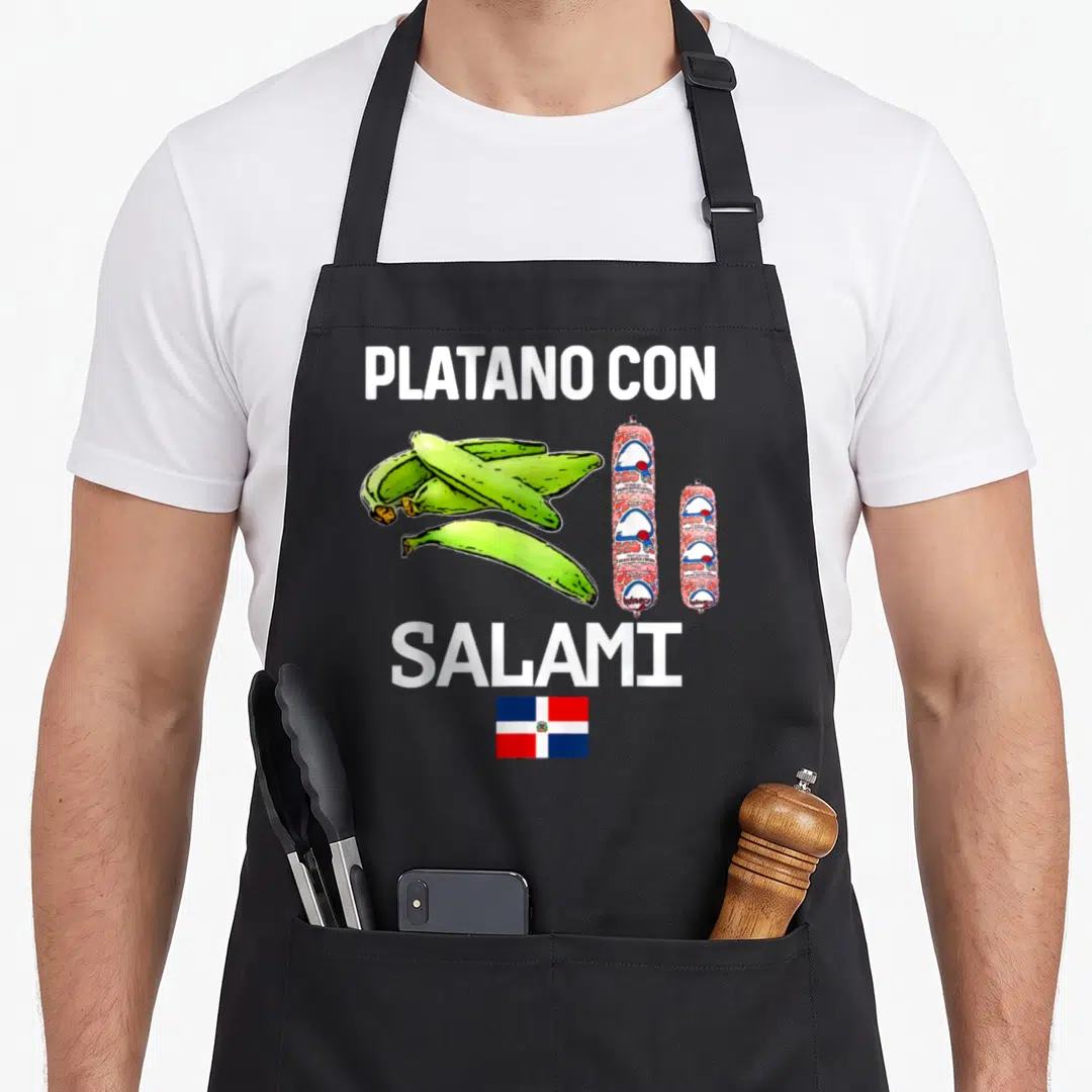 Dominicana food aprons - PLATANO CON SALAMI text with green plantains, two salami sticks, and Dominican Republic flag — shown on a black cotton canvas apron against a white background