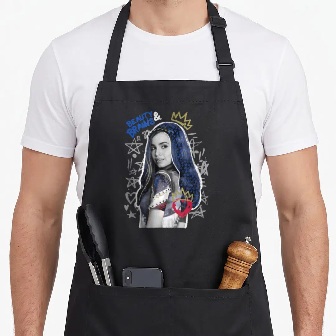 Evie novelty apron - Photo of Evie with BEAUTY & BRAINS text, gold crowns, red heart, and white stars — shown on a black cotton canvas apron against a white background