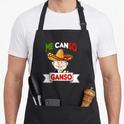 Canso mexico apron - Cartoon man in sombrero with ME CANSO GANSO text in green white and red — shown on a black cotton canvas apron against a white background