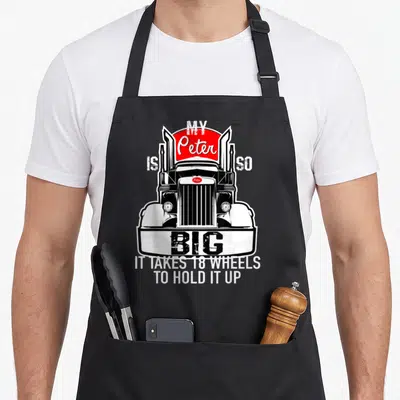 Trucker truck apron - Semi-truck graphic with My Peter is so Big 18 wheels text in white black and red — shown on a black cotton canvas apron against a white background