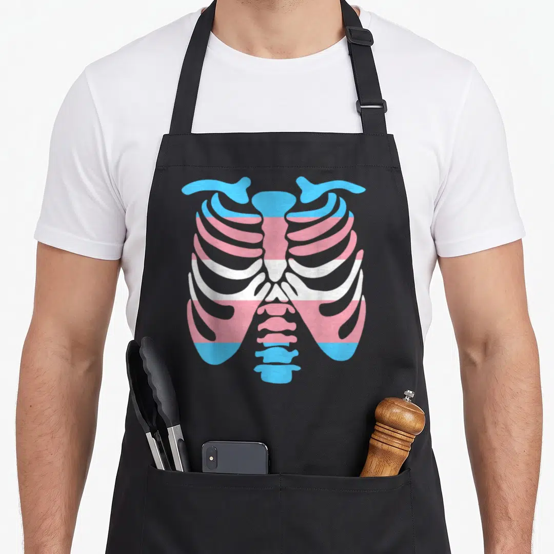 Transgender ribs apron - Ribcage outline filled with horizontal blue pink and white transgender pride flag stripes — shown on a black cotton canvas apron against a white background