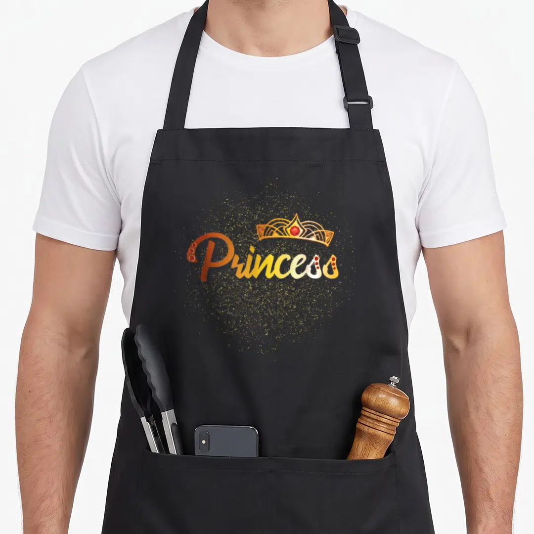 Family princess apron - Gold Princess text with crown and glitter cloud on black bib — shown on a black cotton canvas apron against a white background