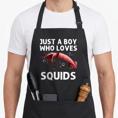 Seafood squid lover apron - Red squid illustration with white bubbles and text JUST A BOY WHO LOVES SQUIDS — shown on a black cotton canvas apron against a white background