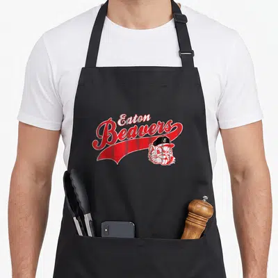 Eaton beaver apron - Eaton Beavers text above red banner with beaver head in baseball cap — shown on a black cotton canvas apron against a white background