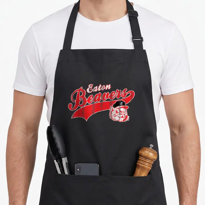 Eaton beaver apron - Eaton Beavers text above red banner with beaver head in baseball cap — shown on a black cotton canvas apron against a white background