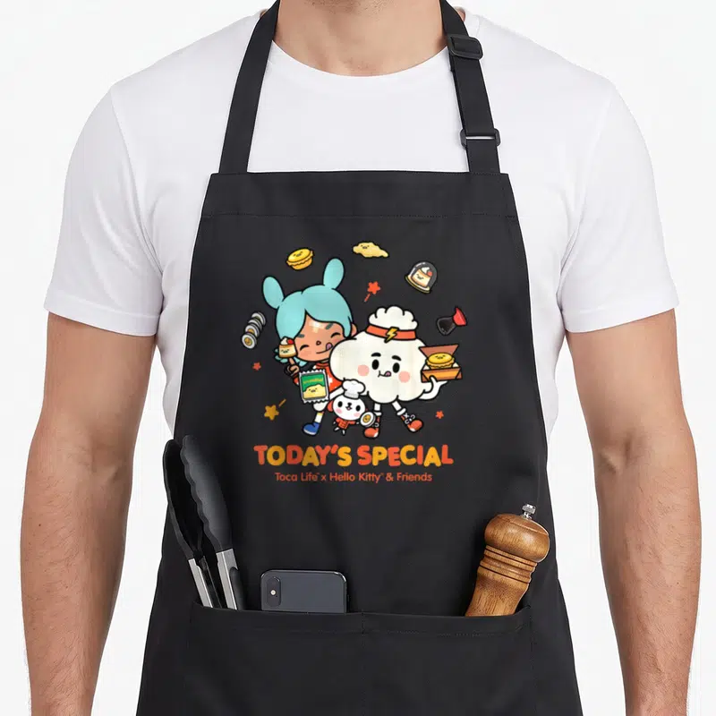 Toca special aprons - Two cartoon characters holding food items with TODAY'S SPECIAL text below — shown on a black cotton canvas apron against a white background