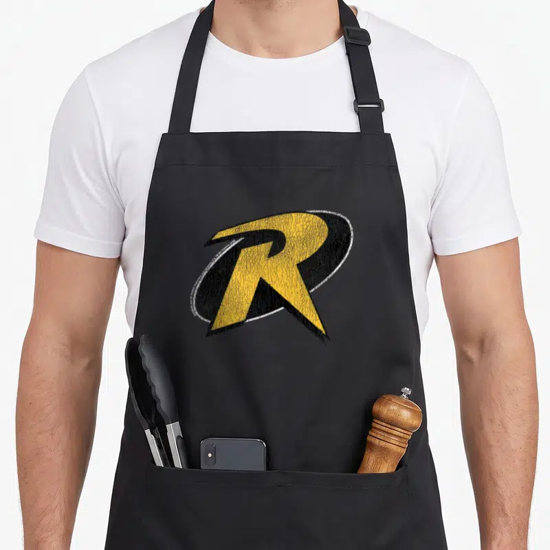 Cute robin animal apron - Distressed yellow and black letter R logo with white outline — shown on a black cotton canvas apron against a white background