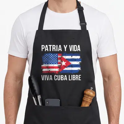 Cuban country american flag apron - Merged US and Cuba flags with PATRIA Y VIDA text in distressed white red and blue — shown on a black cotton canvas apron against a white background