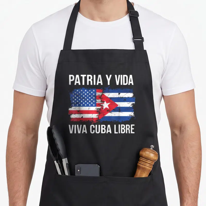 Cuban country american flag apron - Merged US and Cuba flags with PATRIA Y VIDA text in distressed white red and blue — shown on a black cotton canvas apron against a white background