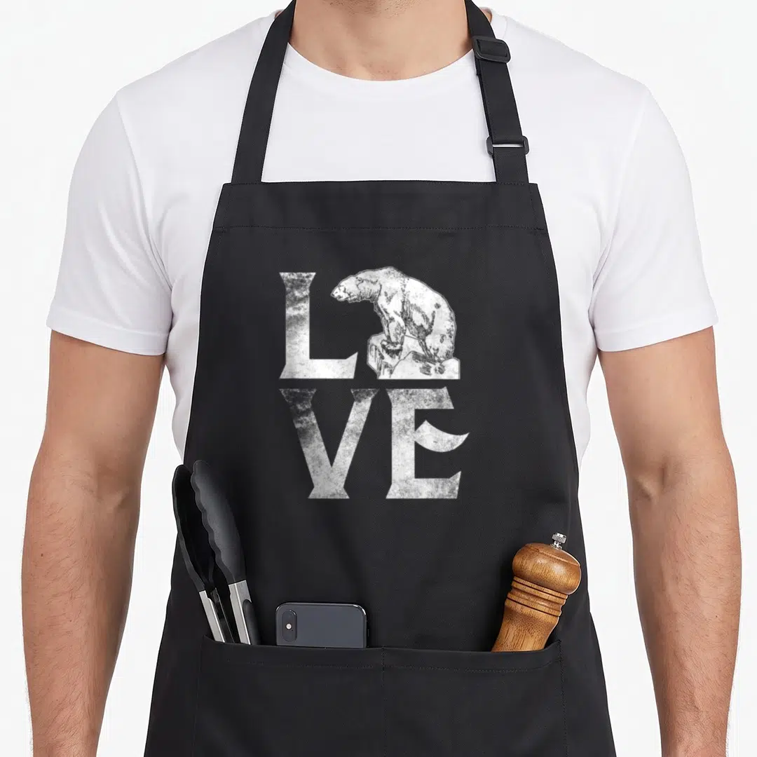 Polar change apron - Distressed white LOVE text with bear standing on rock replacing the O — shown on a black cotton canvas apron against a white background