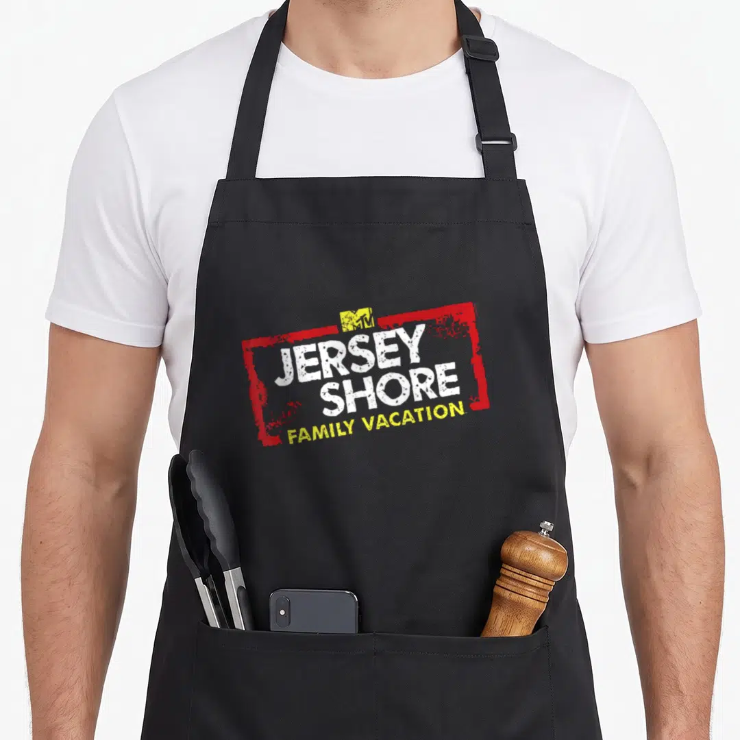Mtv family aprons - Red distressed frame with white JERSEY SHORE and yellow FAMILY VACATION text — shown on a black cotton canvas apron against a white background
