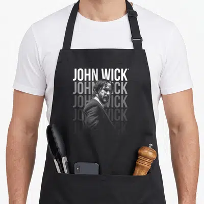 John crew apron - Man in suit photo overlapping three lines of JOHN WICK text in grey and white — shown on a black cotton canvas apron against a white background