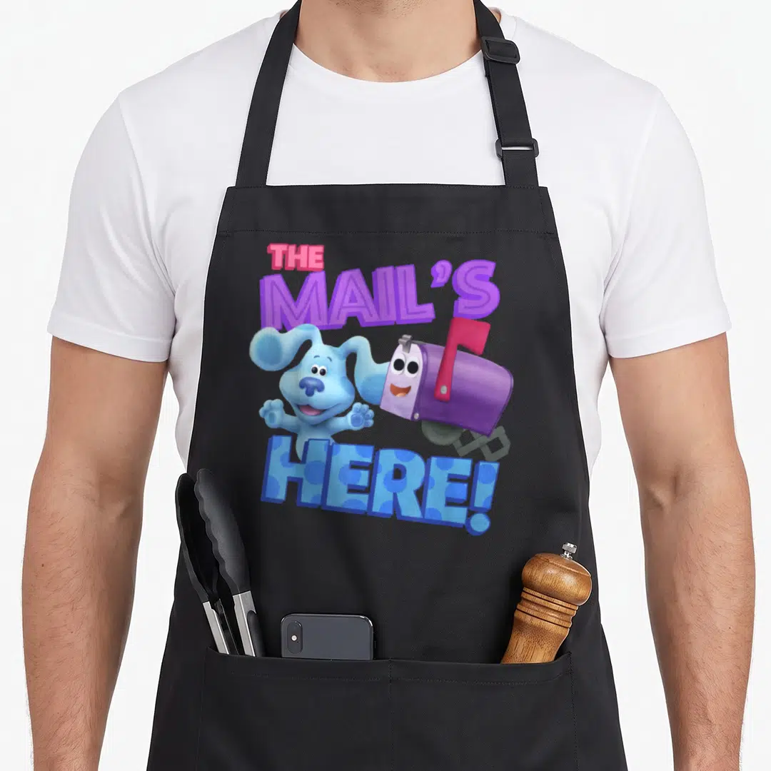 Mail clue apron - Blue dog and purple mailbox with THE MAIL'S HERE! text in cartoon style — shown on a black cotton canvas apron against a white background