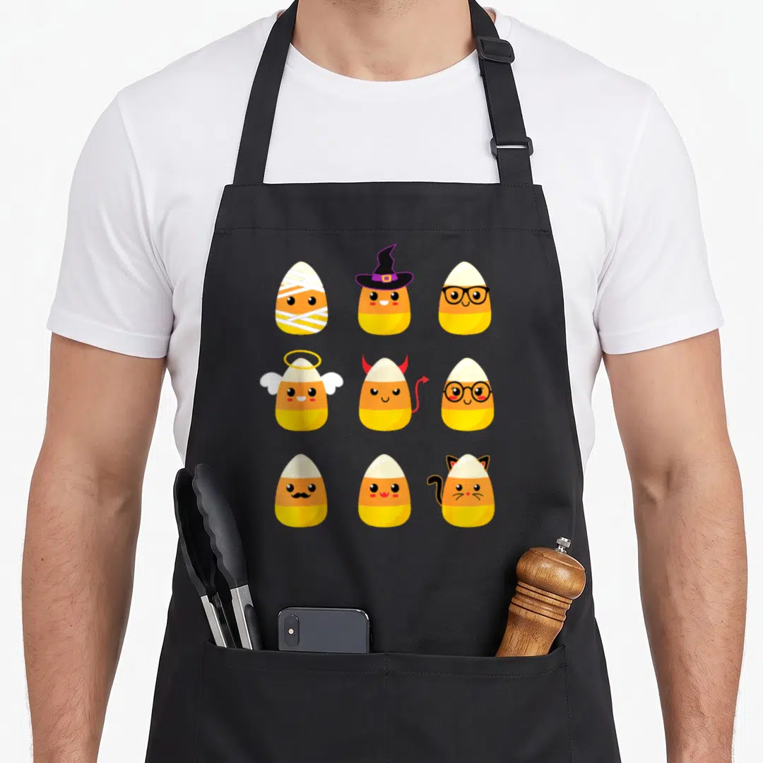 Corn costume halloween apron - Nine candy corns in mummy, witch, angel, devil, cat, vampire, nerd, mustache costumes — shown on a black cotton canvas apron against a white background