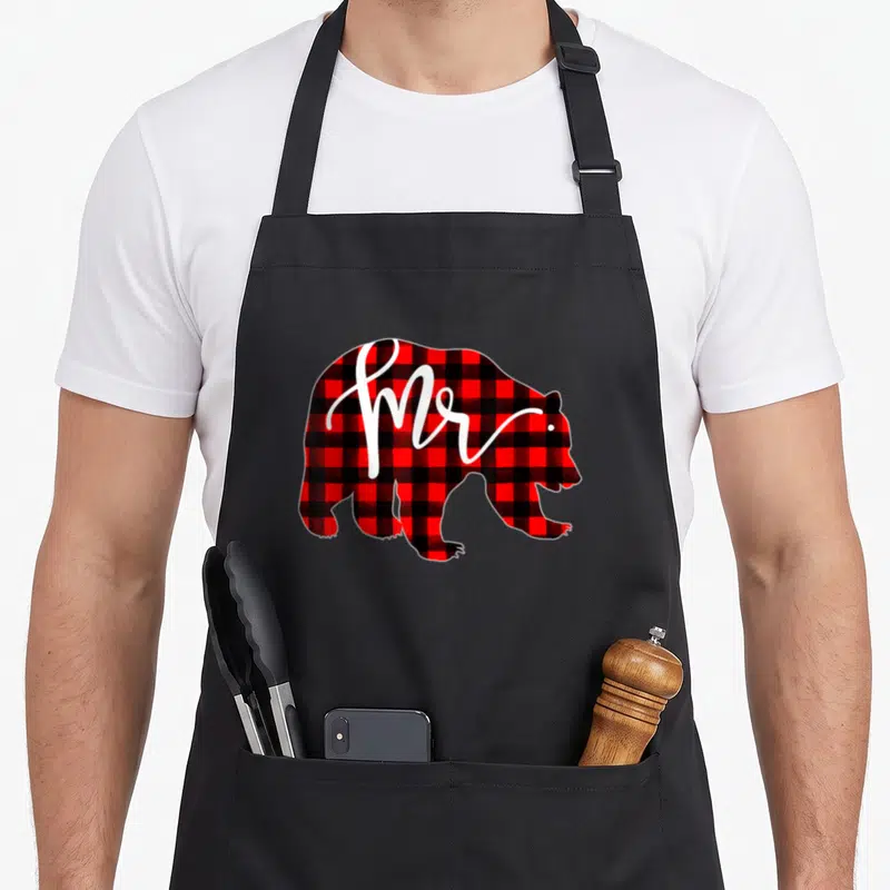 Plaid newlywed aprons - Red and black plaid bear silhouette with white Mr. script text — shown on a black cotton canvas apron against a white background