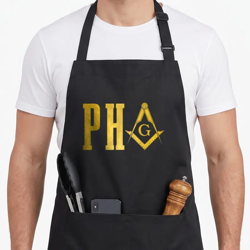 Hall mason apron - Gold PH letters beside a square and compass containing the letter G — shown on a black cotton canvas apron against a white background
