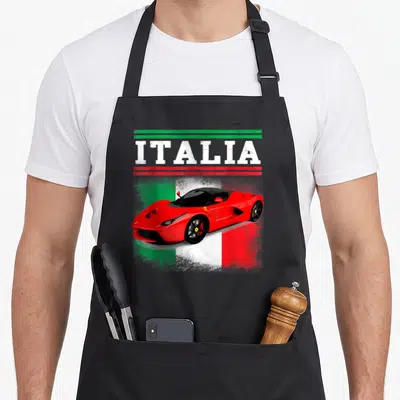 Exotic italian apron - Red supercar below ITALIA text and green red stripes on distressed flag background — shown on a black cotton canvas apron against a white background