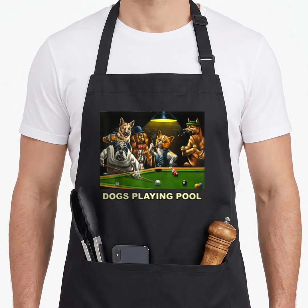 Pool dog apron - Realistic painting of dogs around a green pool table under a yellow lamp with text below — shown on a black cotton canvas apron against a white background