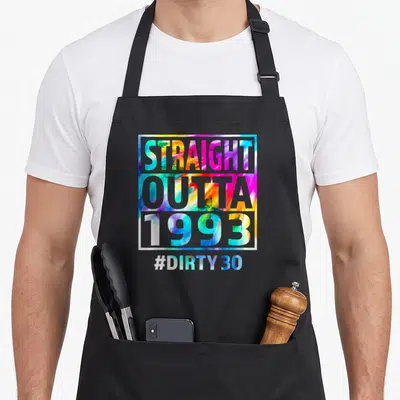 Outta funny dirty aprons - STRAIGHT OUTTA 1993 and #DIRTY 30 text on multicolored square background — shown on a black cotton canvas apron against a white background