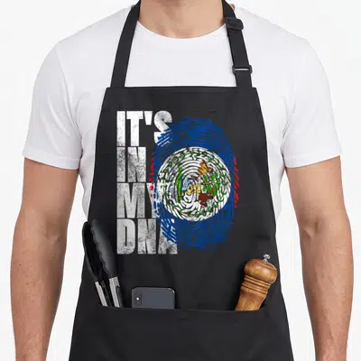 Dna belizean apron - Stacked IT'S IN MY DNA text beside a blue and red fingerprint containing the Belizean coat of arms — shown on a black cotton canvas apron against a white background