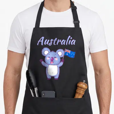 Toddler australian apron - Cartoon koala holding flag under arched Australia text in purple and blue — shown on a black cotton canvas apron against a white background