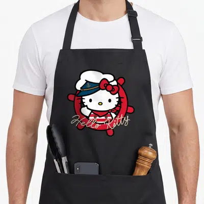 Sailor nautical apron - Hello Kitty in red lifebuoy with blue sailor hat and rope text — shown on a black cotton canvas apron against a white background