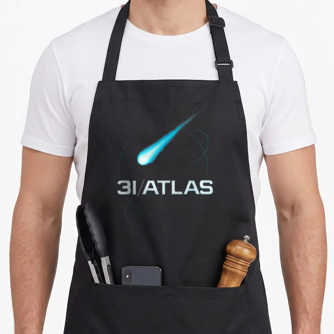 Interstellar atlas apron - Blue comet streaking diagonally above 3I/ATLAS text with thin orbital rings — shown on a black cotton canvas apron against a white background
