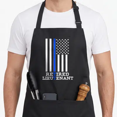 Lieutenant retirement apron - Distressed flag with blue stripe and retired lieutenant text — shown on a black cotton canvas apron against a white background