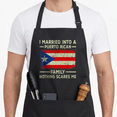 Rican wedding apron - Distressed Puerto Rican flag between text reading I Married Into A Puerto Rican Family Nothing — shown on a black cotton canvas apron against a white background