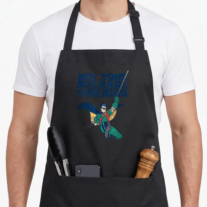 Animated animal apron - Robin leaping below stacked blue text NOT YOUR AVERAGE SIDEKICK — shown on a black cotton canvas apron against a white background