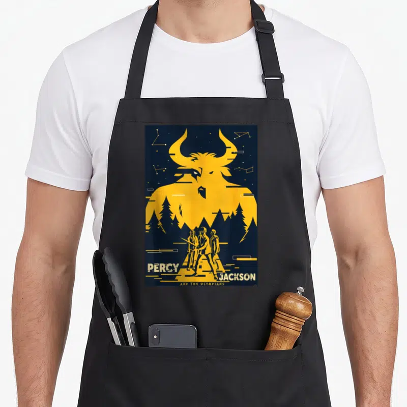 Percy minotaur apron - Yellow Minotaur silhouette, three people, constellations, PERCY JACKSON AND THE OLYMPIANS text — shown on a black cotton canvas apron against a white background