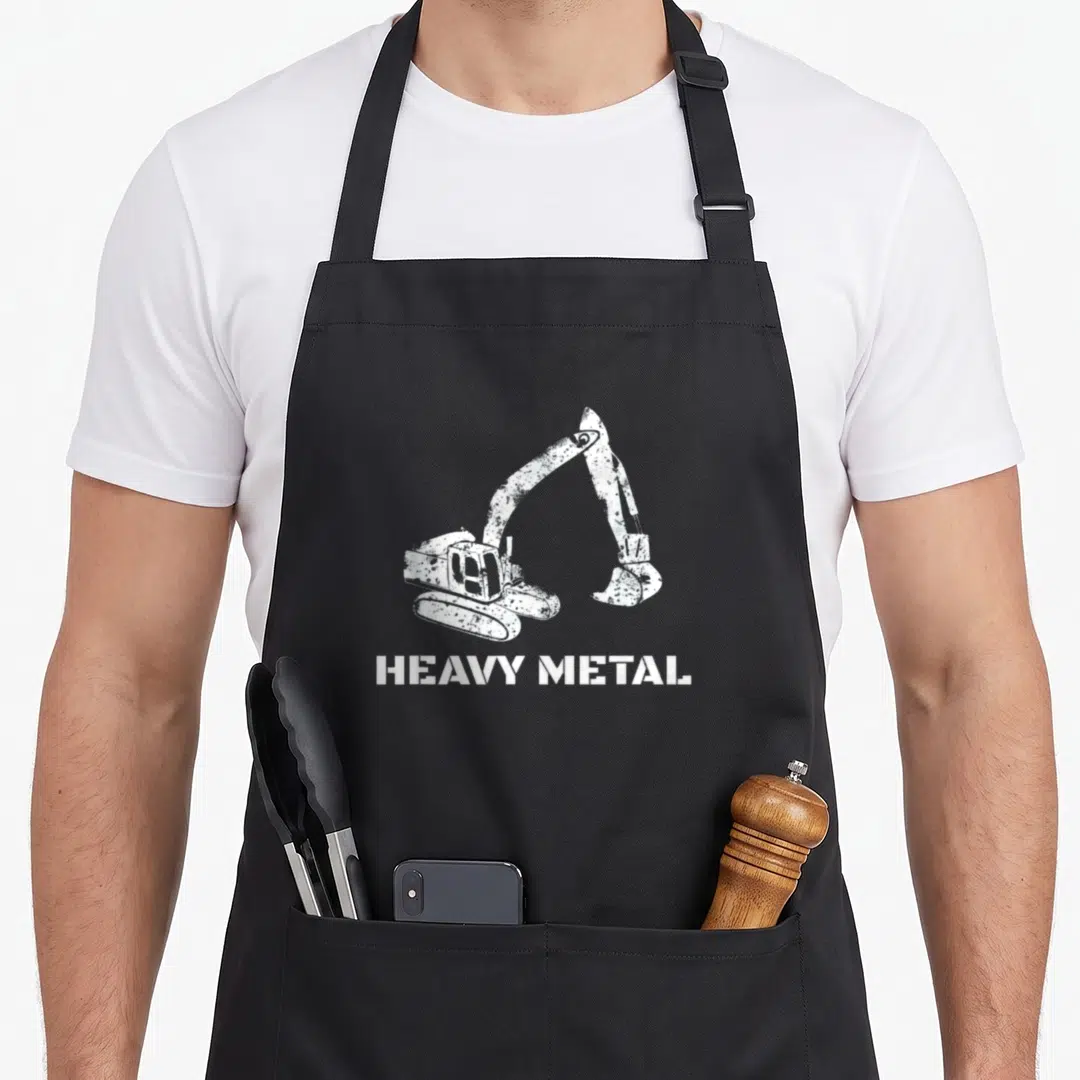 Digger heavy metal apron - Distressed white excavator above HEAVY METAL text — shown on a black cotton canvas apron against a white background