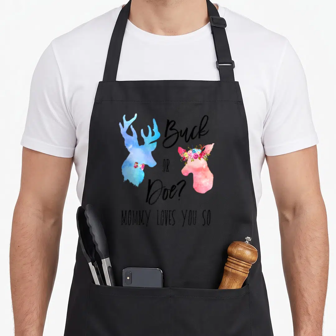 Funny boho apron - Blue buck and pink doe watercolor silhouettes with floral crown and gender reveal text — shown on a black cotton canvas apron against a white background